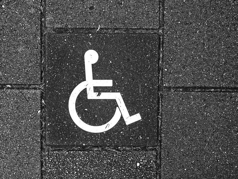 Ein Rollstuhlsymbol auf dem gepflasterten Boden.