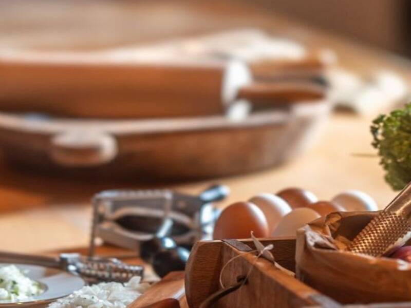 ein Tisch mit Zutaten, Kräutern, Besteck zum Kochen.