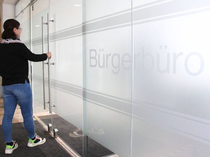 Hier ist eine Frau zu sehen, die ins Bürgerbüro der Stadt Metzingen geht. 