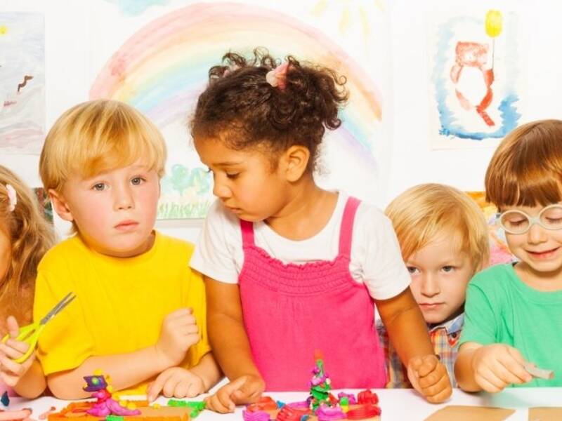 Hier sind viele Kinder zu sehen in bunter Kleidung. 