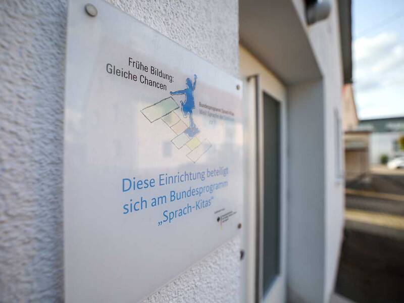 Ein Schild an einer Wand informiert darüber, dass die Einrichtung am Bundesprogramm „Sprach-Kitas“ teilnimmt.