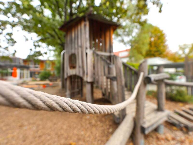 Balancierparcours: Ein dickes Seil führt zu einem Holzspielhaus.