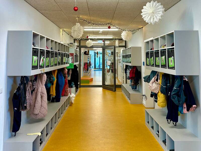 Eingangsbereich des Kindergartens mit grauen Garderoben auf beiden Seiten.