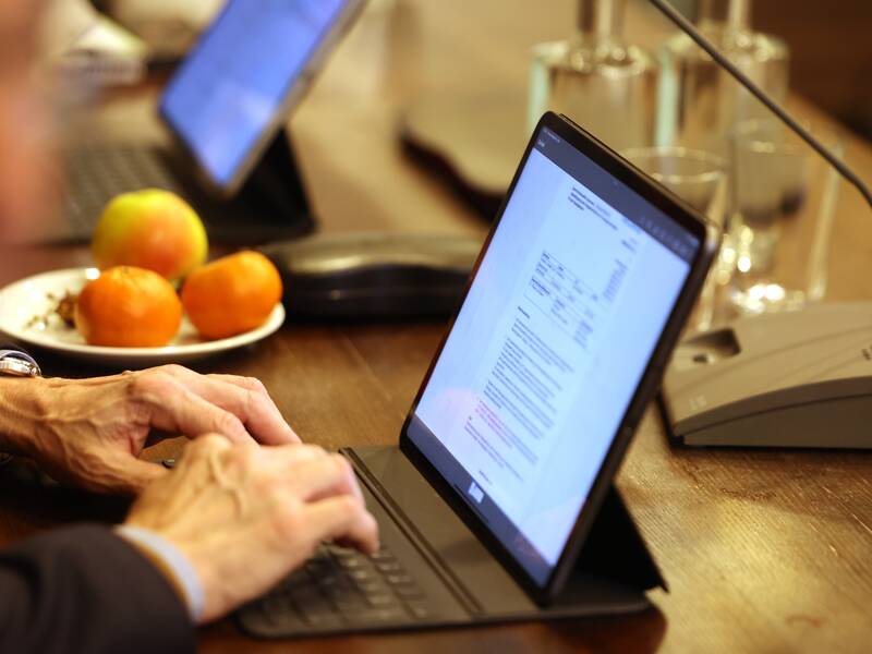 Ein Mitglied des Gemeinderats der Stadt Metzingen sitzt am Laptop und Mikro im Großen Sitzungssaal. Es ist eine Nahaufnahme auf die Hand des Gremienmitglieds zu sehen.
