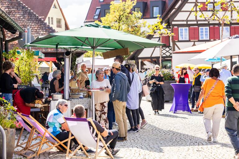 Menschen an einem sonnigen Tag auf dem Kelternplatz