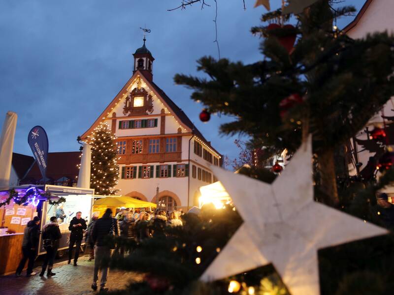 Belebter Weihnachtsmarkt mit dem Metzinger Rathaus im Hintergrund