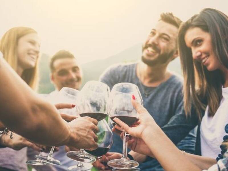 Menschen stoßen mit Weinglas an