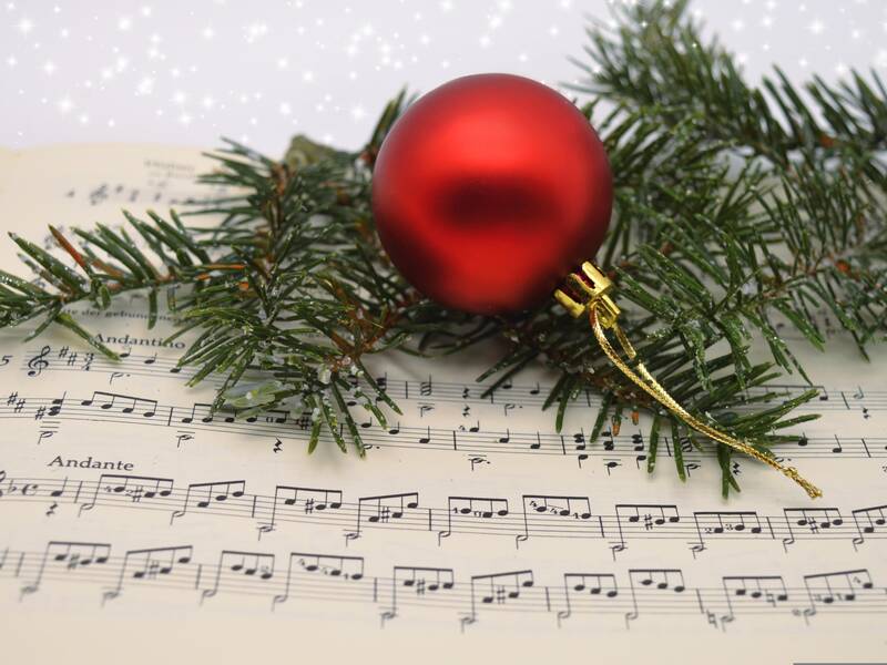 Weihnachtslieder mit Christbaumkugel und Tannenzweig